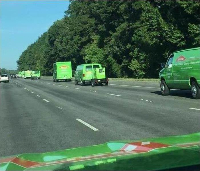 Green vans and trucks driving on highway